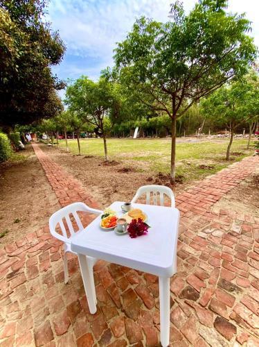 a white table with a plate of food on it at Glamping Girardot & Hotel Puerta Del Sol Girardot in La Virginia