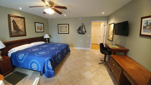 a bedroom with a blue bed and a flat screen tv at Lionheart B&B in Lion's Head