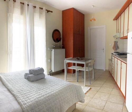 Cet appartement comprend une chambre avec un lit et une table ainsi qu'une cuisine. dans l'établissement Stergios_Apartments 05, à Kozani
