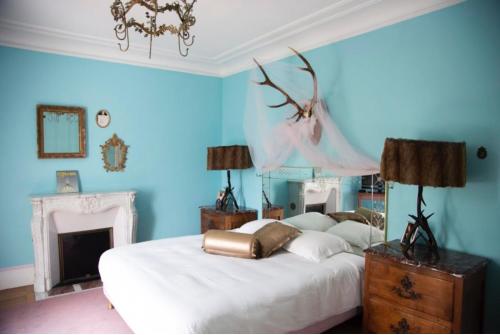 a blue bedroom with two beds and a fireplace at Maison d'hôtes Stella Cadente in Provins