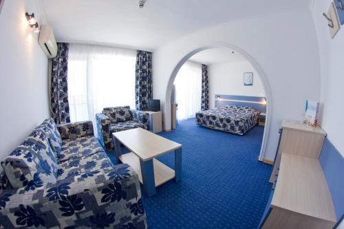 une chambre d'hôtel avec un canapé et un lit dans l'établissement Palace Hotel - Half Board, à Sunny Beach