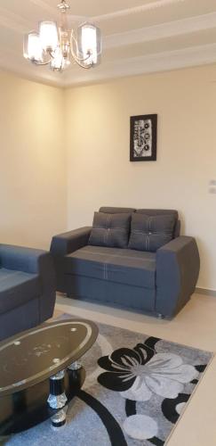 a living room with a blue couch and a table at Appartement meublé à MBAO in Mbaw Gou Ndaw