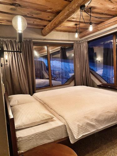 a bedroom with a bed and a large window at Hygge House in Vyshka