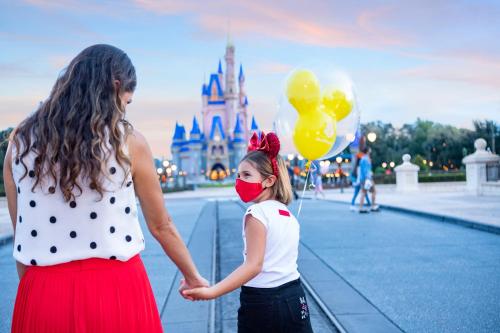 a woman and a little girl standing in front of a castle at Candlewood Suites - Orlando - Lake Buena Vista by IHG in Orlando