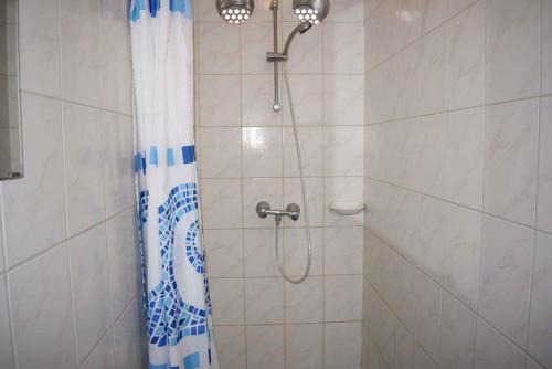 um chuveiro com uma cortina azul e branca na casa de banho em Holiday home in Siofok - Balaton 40757 em Siófok