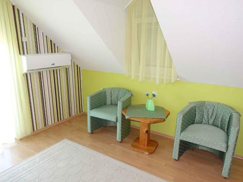 two chairs and a table in a room at Holiday home in Gyenesdias - Balaton 40755 in Gyenesdiás
