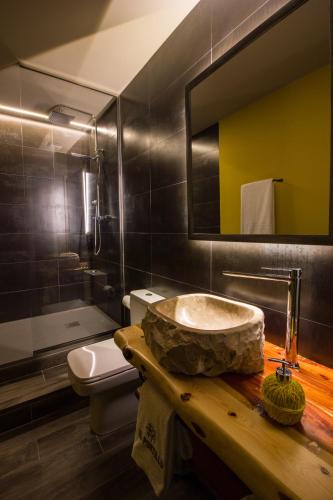a bathroom with a sink and a toilet and a mirror at Casa Rural El Portillo in Cantavieja
