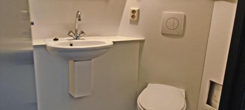 ein weißes Bad mit einem Waschbecken und einem WC in der Unterkunft Hotelhuisje Warmenhuizen #F in Warmenhuizen