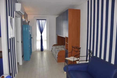 a bedroom with a blue couch and a bed and a window at Apartments in Lazise - Gardasee 40839 in Lazise