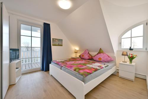 1 dormitorio con 1 cama grande con almohadas rosas en Holiday home in Poseritz - Insel Rügen 41511, en Poseritz