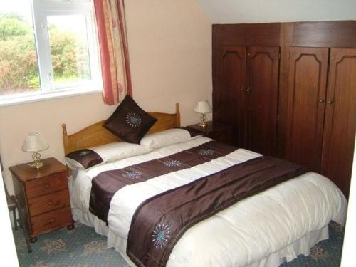 een slaapkamer met 2 bedden en een raam bij Achill Isle House in Keel