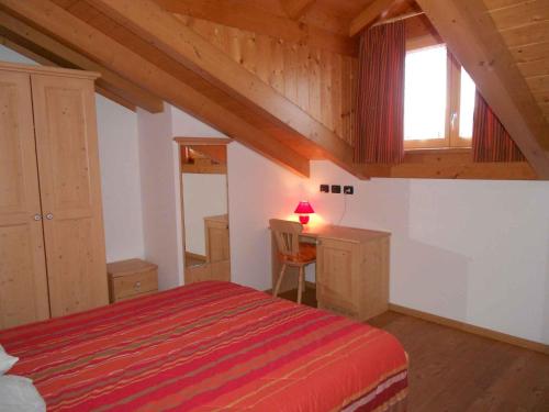 Schlafzimmer mit einem Bett, einem Schreibtisch und einem Fenster in der Unterkunft Apartment in NOVELLA 41460 in Brez