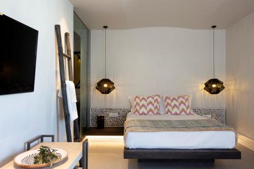a bedroom with a bed and a table and lights at Villa Kelly Rooms & Suites in Naousa