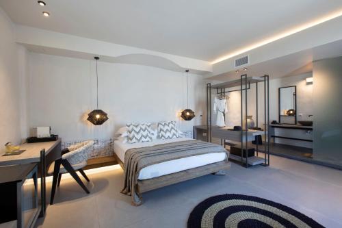 - une chambre avec un lit et un bureau dans l'établissement Villa Kelly Rooms & Suites, à Náoussa