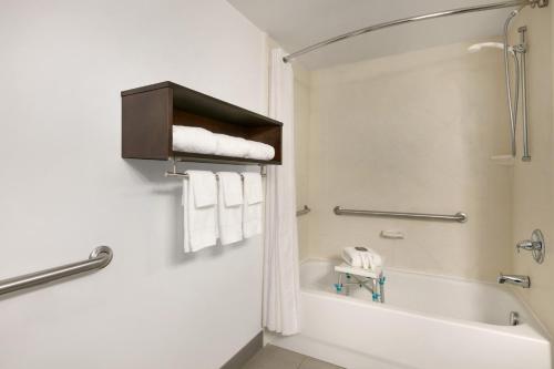 a bathroom with a tub and a toilet and towels at Country Inn & Suites by Radisson, London, KY in London