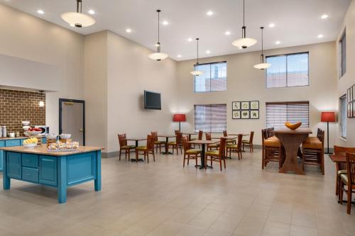 a dining room with tables and chairs and windows at Country Inn & Suites by Radisson, London, KY in London