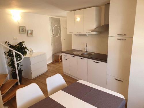 a kitchen with white cabinets and a table and chairs at Apartment in Postojna 40257 in Postojna
