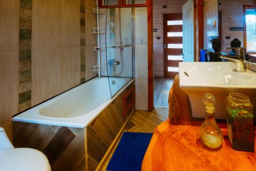 y baño con bañera y lavamanos. en The Sirena Insolente Hostel, en Pichilemu