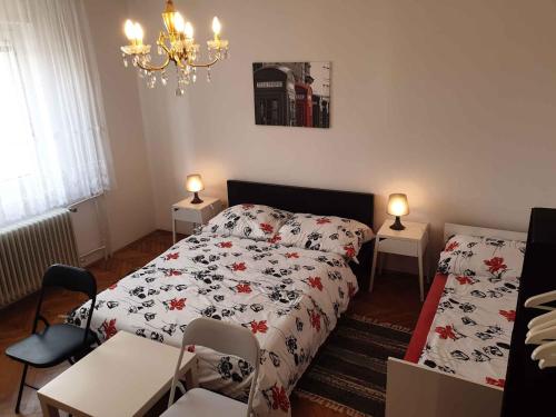 1 Schlafzimmer mit einem Bett, 2 Tischen und einem Kronleuchter in der Unterkunft Apartment in Postojna 40258 in Postojna