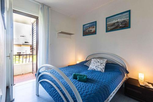 a bedroom with a bed with a blue comforter at Holiday home Porto Santa Margherita 40296 in Porto Santa Margherita di Caorle