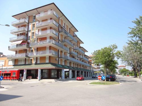 un gran edificio de apartamentos en una calle de la ciudad en Apartments Porto Santa Margherita 40282, en Porto Santa Margherita