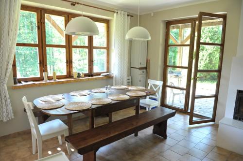 - une cuisine et une salle à manger avec une table et des chaises dans l'établissement Dom nad Strugą, à Słuchowo