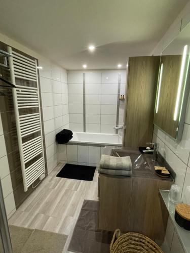 a bathroom with a bath tub and a sink at LOVE Suites & SPA "Le Loft" avec Jacuzzi privatif in Médis