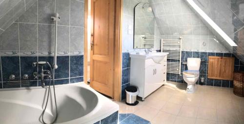 łazienka z wanną, umywalką i toaletą w obiekcie Holiday home in Balatonalmadi 38980 w mieście Balatonalmádi
