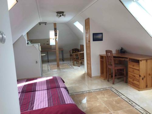 a attic room with a desk and a table at Holiday home in Balatonalmadi 38980 in Balatonalmádi