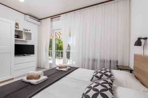 a bedroom with a large bed and a television at Apartments in Moscenicka Draga 34827 in Mošćenička Draga