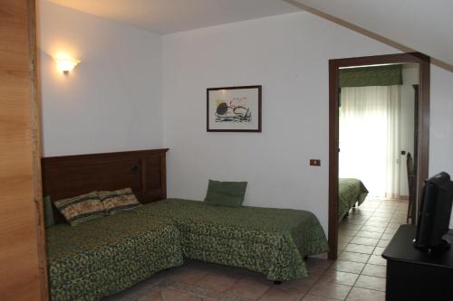 a bedroom with a bed and a television in it at Residence La Piscina in Isola del Gran Sasso dʼItalia