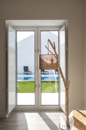 a room with sliding doors with a view of a pool at Pé no Campo Suites and Villa in Carvalhal