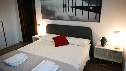 - une chambre avec un lit blanc et un oreiller rouge dans l'établissement Holiday home in Lazise/Gardasee 39034, à Lazise