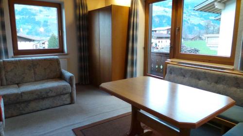 a living room with a couch and a table and two windows at Apartments in Kaltenbach/Zillertal 751 in Kaltenbach