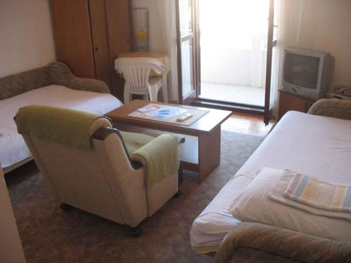 Una habitación con dos camas y una mesa y un televisor. en Apartment in Kukljica - Insel Ugljan 38785, en Kukljica