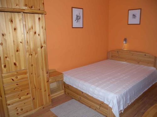 1 dormitorio con 1 cama y armario de madera en Apartment in Balatonöszöd 20195, en Balatonőszöd