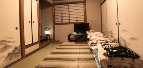 a room with a bed and a desk with a computer at Nakagawa's Cozy House in Sakai