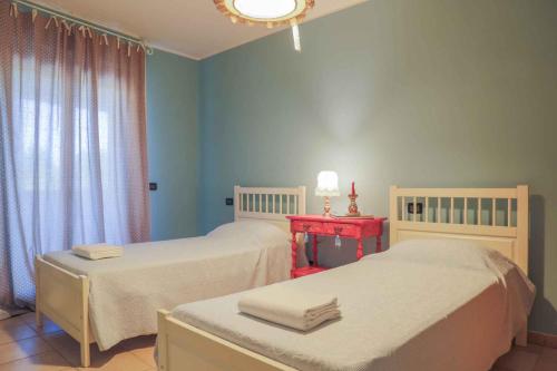 Habitación con 2 camas y mesa roja. en Apartment in Poggibonsi/Toskana 38410 en Poggibonsi