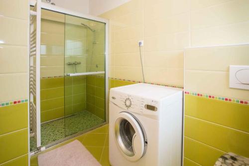 La salle de bains est pourvue d'une douche et d'un lave-linge. dans l'établissement Apartment in Porec/Istrien 39700, à Poreč