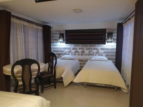 Habitación de hotel con 2 camas y 2 sillas en Hotel Kachi de Uyuni en Uyuni