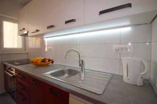 - une cuisine avec un évier et un bol de fruits dans l'établissement Apartment in Porec/Istrien 38642, à Poreč