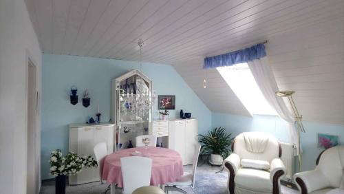 ein Esszimmer mit einem rosa Tisch und Stühlen in der Unterkunft Apartment in Eibenstock 30354 in Eibenstock
