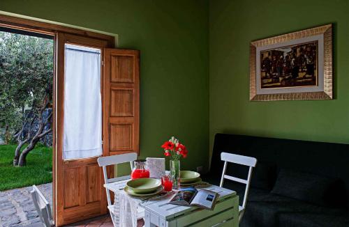 um quarto com uma mesa e cadeiras e uma parede verde em Apartment in Linguaglossa/Sizilien 38037 em Linguaglossa
