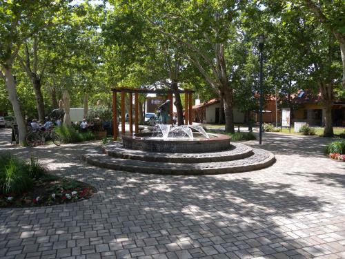 a fountain in the middle of a park with trees at Apartment in Balatonboglar 38010 in Balatonboglár