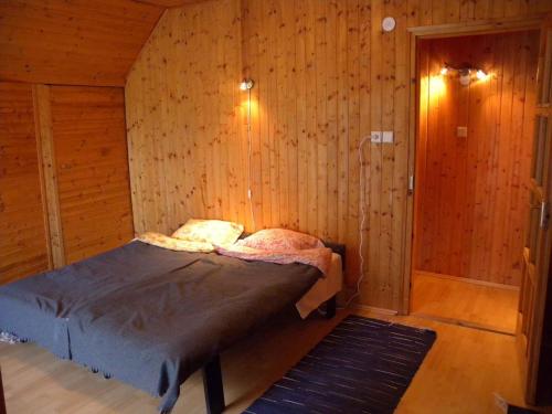 een slaapkamer met een bed in een houten kamer bij Holiday home in Fonyod/Balaton 38001 in Fonyód