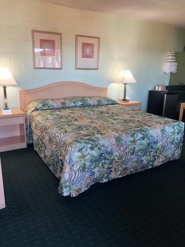 a large bed in a hotel room with two lamps at Seahorse Inn in Manhattan Beach