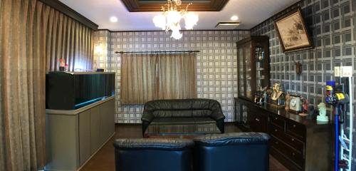 a living room with a tv and a chair at Nakagawa's Cozy House in Sakai