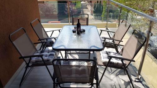 a table and chairs on a balcony with a bottle of wine at Apartments in Siofok - Balaton 38420 in Siófok