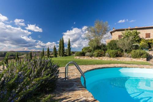 a swimming pool in a garden with a house at Appartamento Il Nido Di Giulia in Asciano