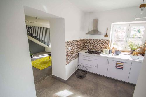 a kitchen with white cabinets and a sink and a staircase at Holiday home in Oprtalj - Istrien 37043 in Oprtalj